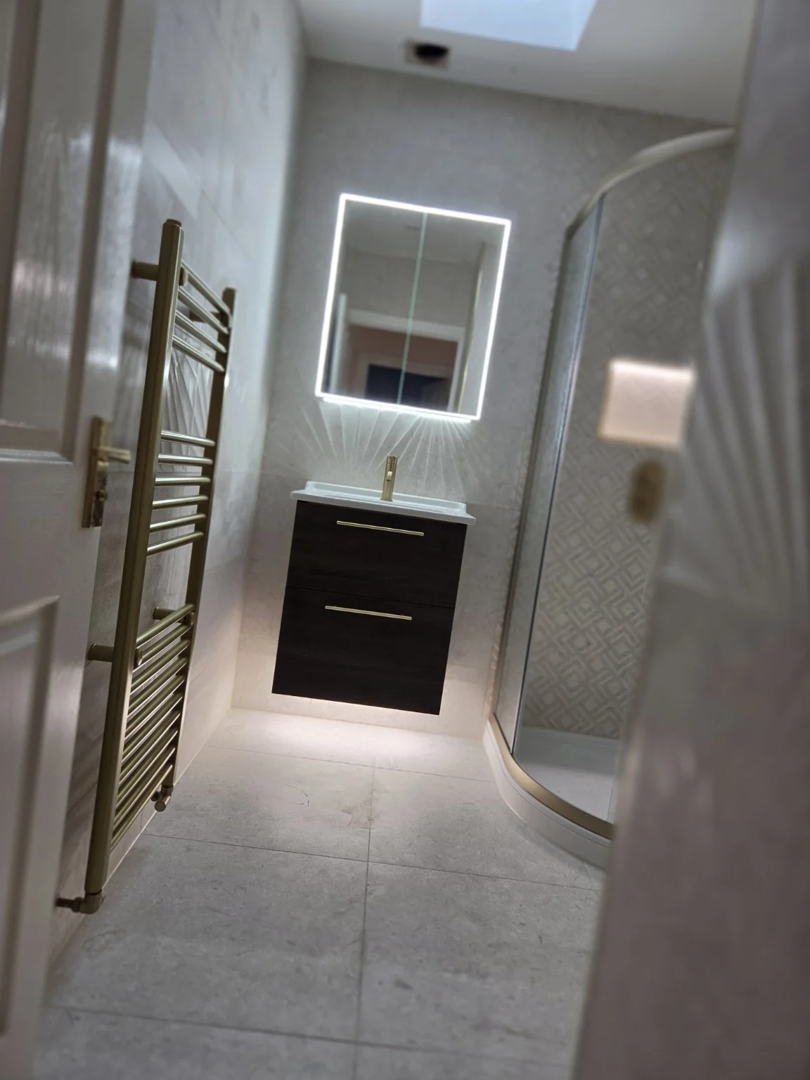 Wide view of illuminated vanity and shower