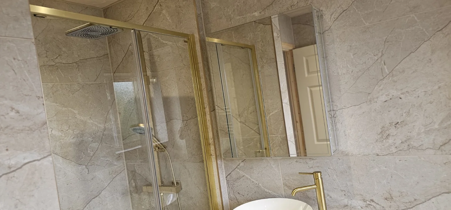 Stone-effect shower with brushed gold enclosure