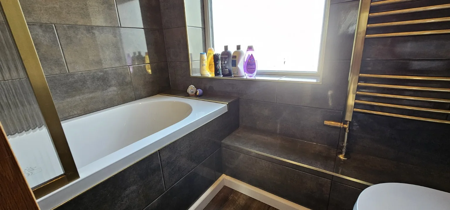 Dark tiled bathroom wide view
